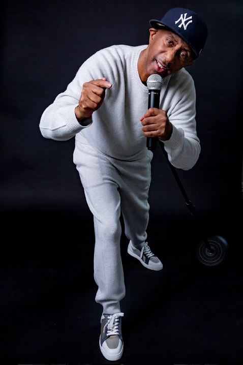 Comedian Sleepy Floyd performing in grey tracksuit with microphone