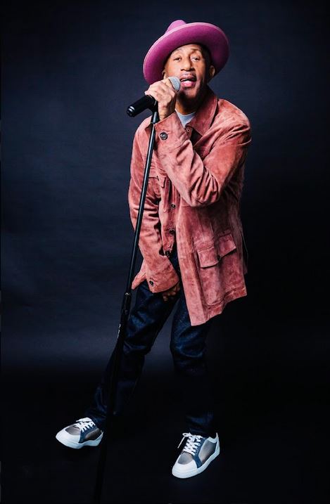 Comedian Sleepy Floyd performing in signature pink suit with purple hat
